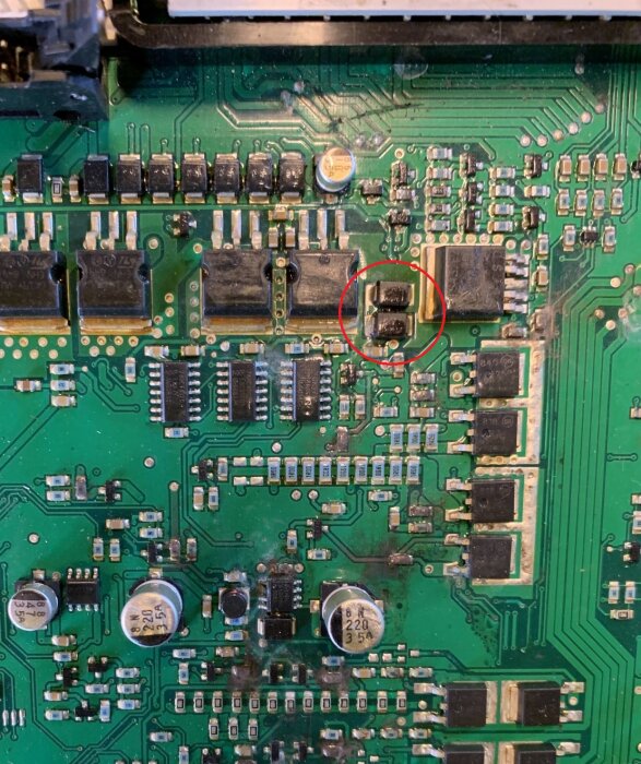 Närbild på ett kretskort med två dioder markerade i rött, omgivna av flera komponenter.