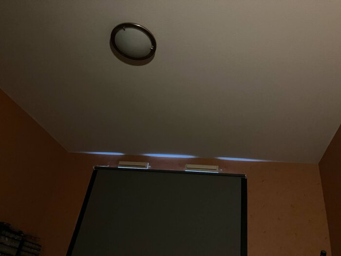 Mörkläggningsgardin med ljusinsläpp längs övre kanten i ett sovrum.