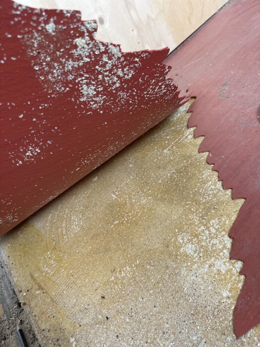 Rödbrun platta med flagor och vit beläggning, misstänkt asbestmaterial.