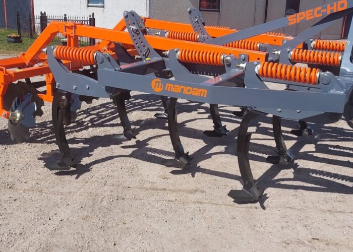 En kultivator av märket Mandam står på marken redo för användning.
