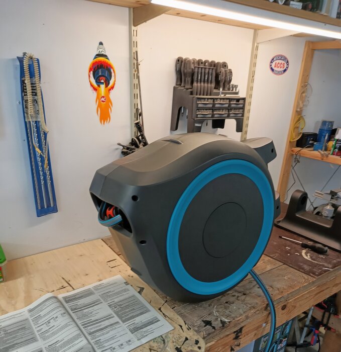 En Gardena XL 35 slangvinda placerad på en arbetsbänk i ett verktygsutrustat garage eller verkstad.