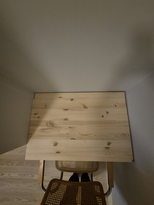 Träskrivbord fastsatt mot sneda väggen och sidan av garderoben med synliga glipor; sned sågning; fråga om bästa sättet att täcka springorna.