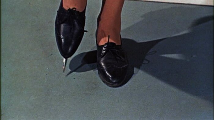 En svart sko med en utstickande dolkklinga från sulan, inspirerad av Rosa Klebbs sko från en James Bond-film.