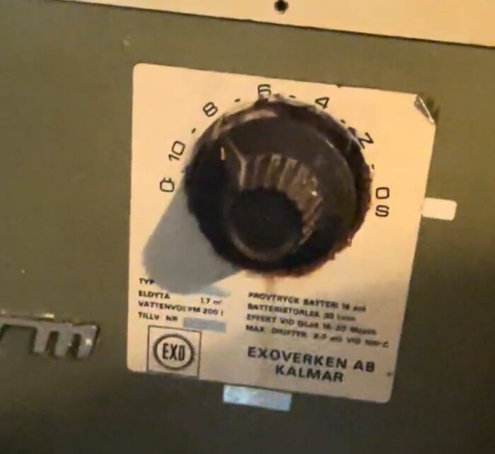 Gammal Exonom oljepanna med ratt, märkt “Exoverken AB Kalmar”, uppvisar specifikationer för vattenvolym och effekt.