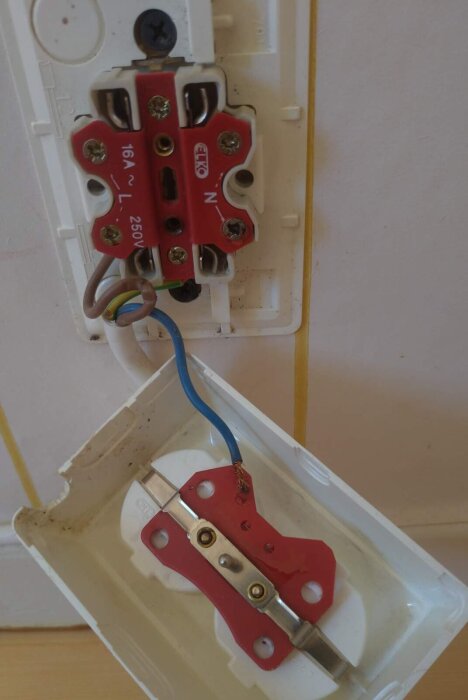 Elektrisk kontakt med öppen kåpa där nollan ligger osäkert, bränd plast och isolering på skyddsjorden är skadad.