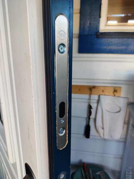 Närbild av ett nyinstallerat dörrlås från Yale i en dörrkarm, med synliga skruvar och trädetaljer.