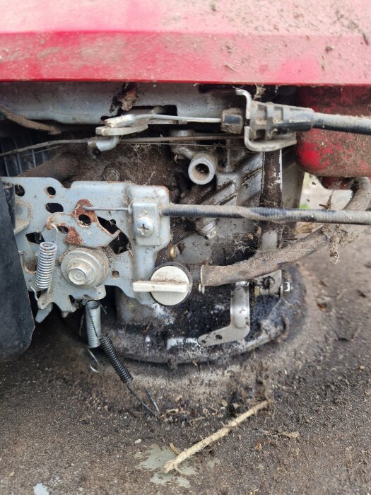 Bild på en smutsig motor med synliga fjädrar och komponenter från en Honda HRS536 gräsklippare.