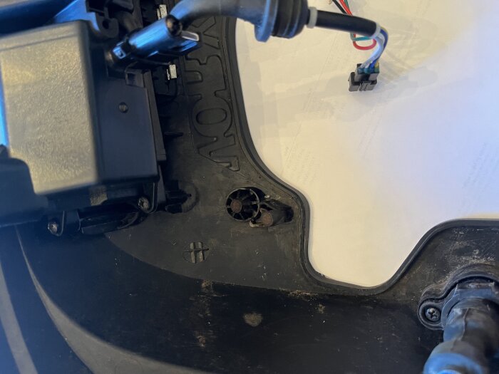 Insidan av en Worx Landroid WG790 med små magneter och kretskort synliga på frontramen.