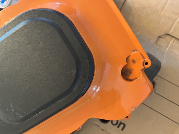 Insida av en Worx Landroid WG790 med orange hölje och små utskärningar, potentiellt plats för magneter eller kretskort.