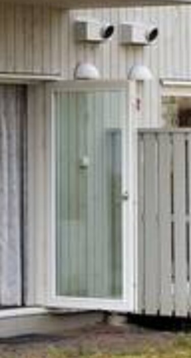 Två ventiler ovanför en glasdörr på en ljus träfasad, troligen för luftväxling med FTX-system mellan anslutande kök.