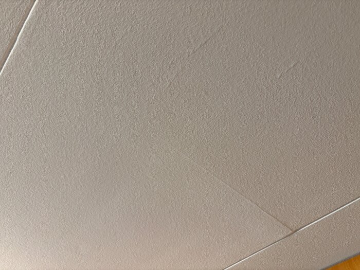 Innertak med skrovlig textur och sprickor i skarvarna mellan takskivorna.
