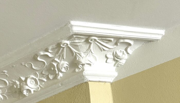 Detaljerad hörnlist med blommönster och dekorativa inslag, del av ett byggprojekt.