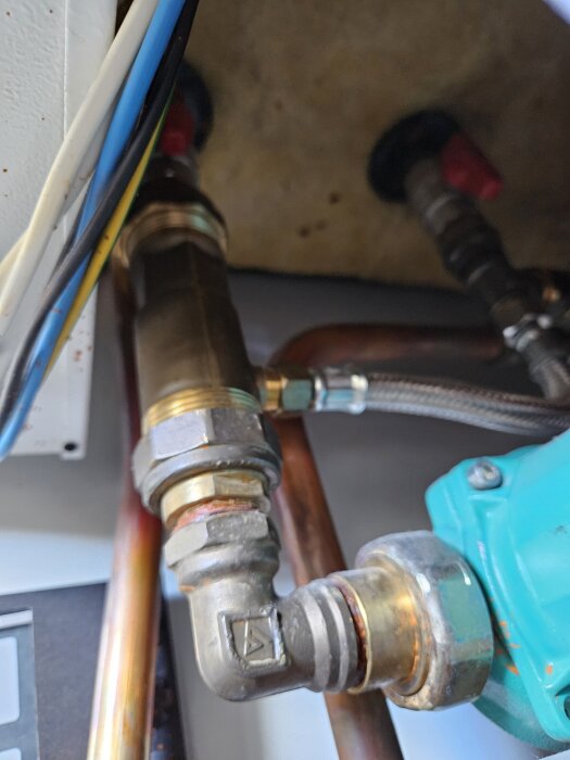 Ventil och rördelar under diskbänk i behov av reglerventil för tappvarmvatten.