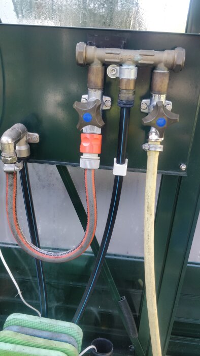 Vattenfördelare med flera anslutningar, inklusive PEM-slangar och ventiler för manuell och automatisk styrning av vattenflödet.