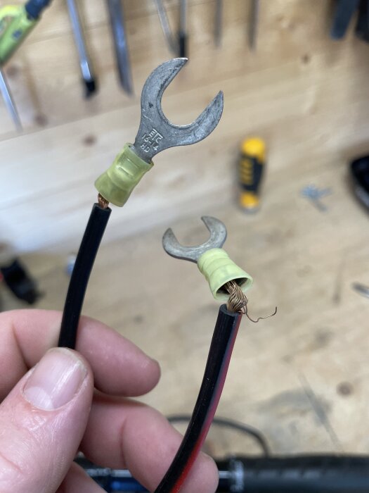 Brända kablar med gröna kabelskor i närbild, eventuellt från en trasig elmotor.