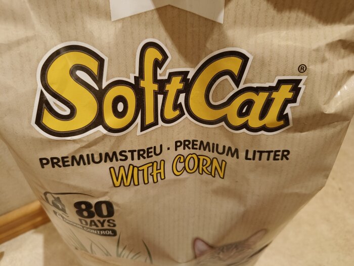 Paket av kattsand märkt "SoftCat Premium Litter with Corn", lovar luktfrihet i 80 dagar.