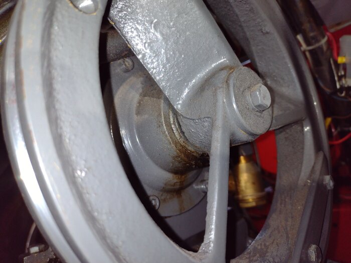 Närbild av en kompressordel med fokus på vevhuset och en bult, möjlig läckage synligt vid tätningen.