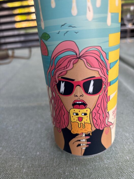 En färgglad ölburk med en tecknad person med rosa hår och solglasögon som äter en glass.