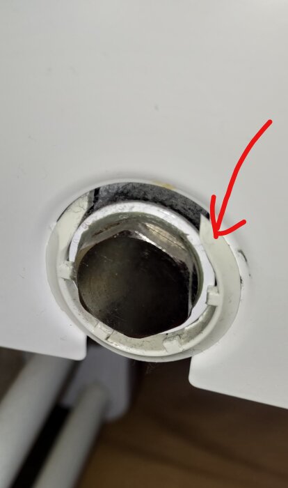 Bild på en plastring vid ett element, med en pil som pekar på ringen. Ringen ser hel ut trots viss smuts och damm.