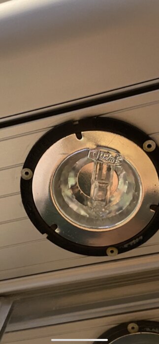 Närbild av en spotlightarmatur i tak med en halogenlampa, där monteringshålen är svåra att se på grund av armaturens vinkel.