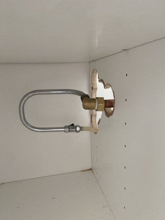 Vinkelanslutning genom hål i skåpvägg, monterad horisontellt. Frågeställning om korrekt position.