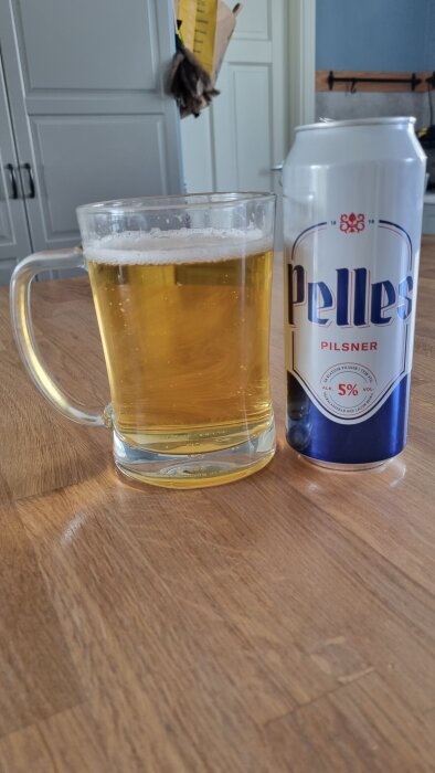Öl i glas och burk med etiketten "Pelles Pilsner" i ett kök.