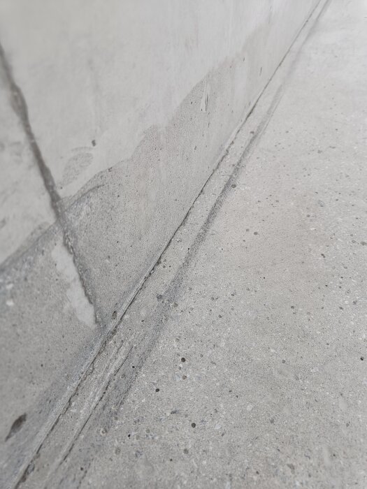 Spricka mellan vägg och bänk, visar ojämnhet i hörn, fokus på problemområde där bänkens översida möter väggen, slitage synligt.