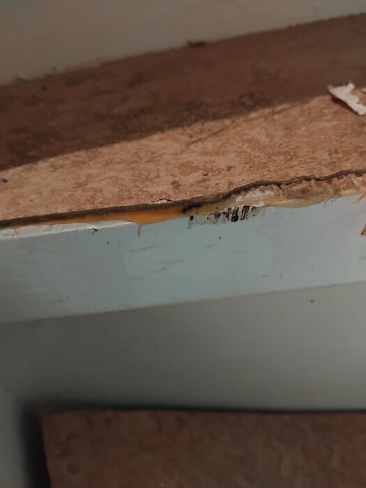 Trappa från 1945 under renovering, visar rött material och lim under sliten trappsteg.