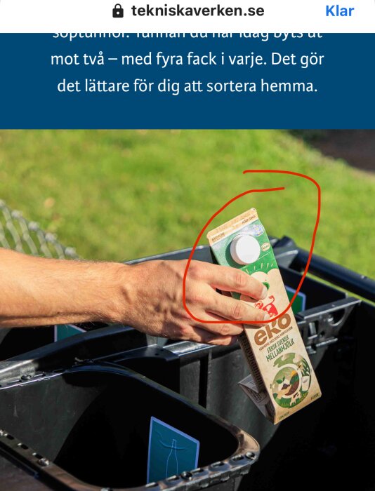 En hand håller en mjölkförpackning över en soptunna markerad för plastsortering, med gräs i bakgrunden.