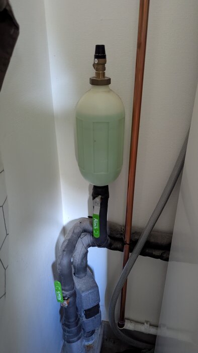 Tryckkärl i VVS-system med isolerade rör och kopparrör, märkt med Altech. Potential felsökningspunkt för bergvärmepumpsproblem.