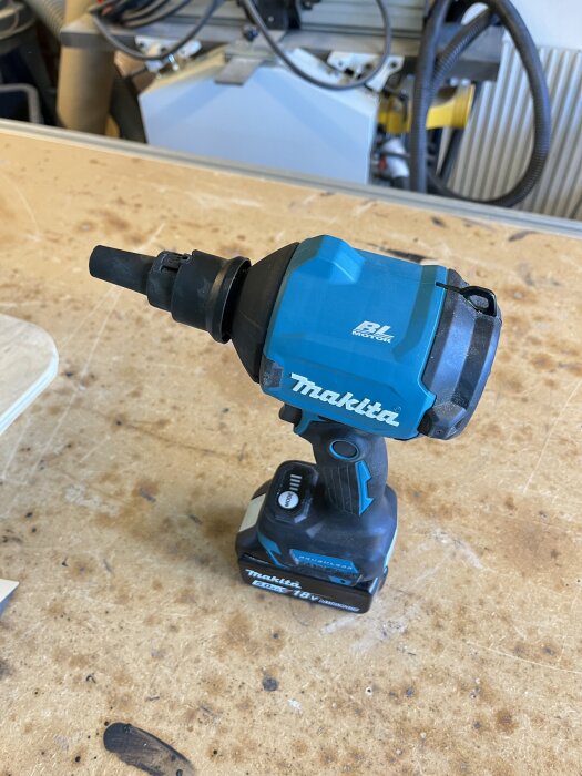 Makita 18V batteridriven slagborrmaskin på ett arbetsbord i verkstadsmiljö.