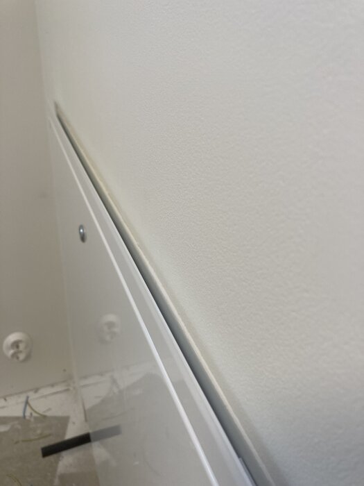 Väggmontering utan ram, med synliga eluttag och kablar.