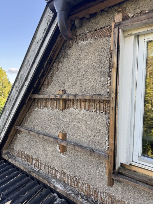 Väggstruktur i ett gammalt hus från 40-talet med synlig puts och träreglar, inga fuktspärrar, intill liggande fönster.