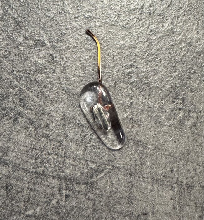 Trasig ljussladd med skadad glödlampa på grått golv.