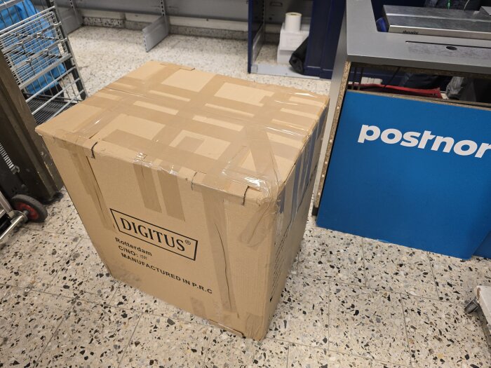 Kartong från Digitus på postkontor, förberedd för retur.