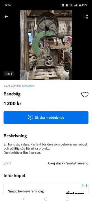 Begagnad grön bandsåg på träpall i verkstad, säljs för 1200 kr. Behöver ses över.