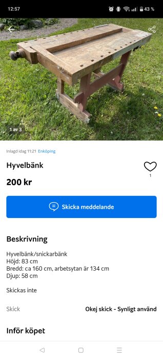 Begagnad hyvelbänk placerad på gräs med synliga märken och slitage.