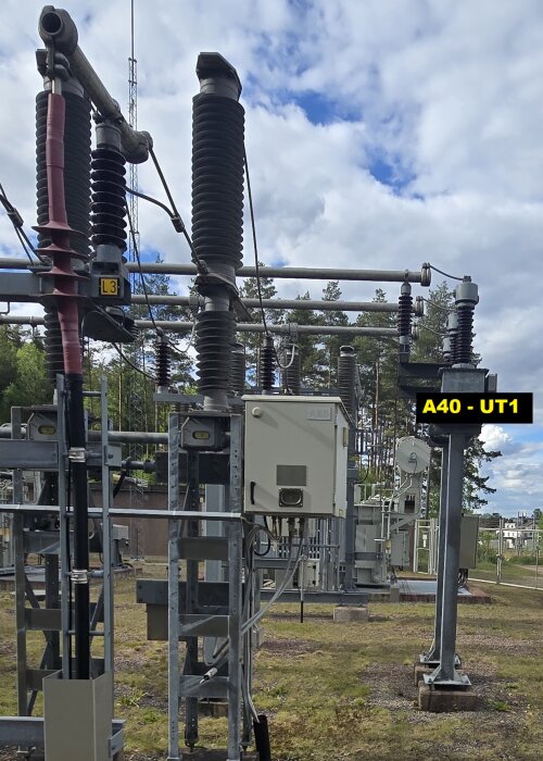 Elstation med kablar, isolatorer och en transformator i en utomhusanläggning, markerad med "A40 - UT1".