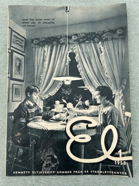 Gamla tidningsannonsen visar två personer vid ett köksbord med duk, lampan ovanför dem och gardiner i bakgrunden, tidningen heter "El" från 1958.