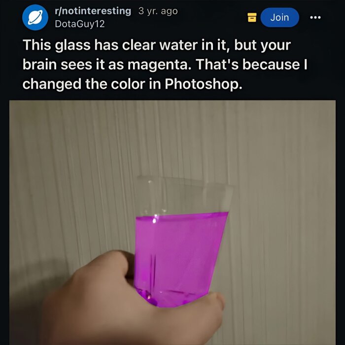 Hand som håller ett glas med magentafärgat vatten, redigerat i Photoshop.