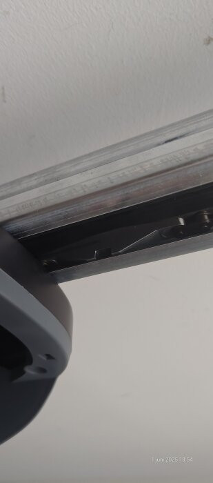 Kedjemekanism på en garageport, med en låsklump i svängen som hindrar driften.