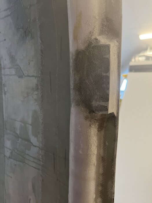 Närbild av en plastad ficka i dörrkarmen, förstärkt med epoxi för montering av låsbleck enligt byggbeskrivningen i inlägget.