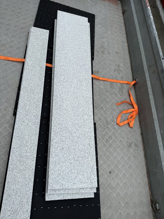 Granitplattor liggande på ett släp, redo att användas för att bygga om en yttertrappa.
