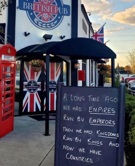British pub med unionsjackan och en svart tavla med text om hur ledarskap har förändrats, från imperier till riken tills nu länder.