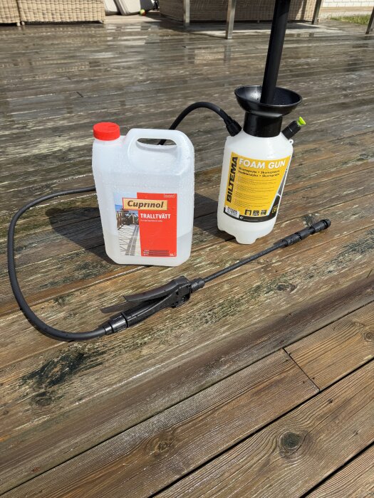 Cuprinol Tralltvätt och Biltema Foam Gun på en rengjord altan, med vattenfläckar synliga på trallen.