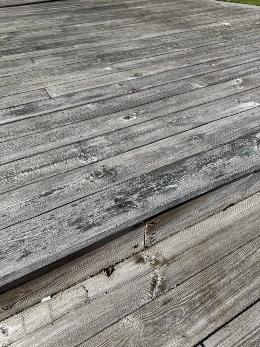 Grå träaltan med slitage och svarta partier, tagen innan rengöring med Kärcher PCL 6 och Cuprinol Tralltvätt.