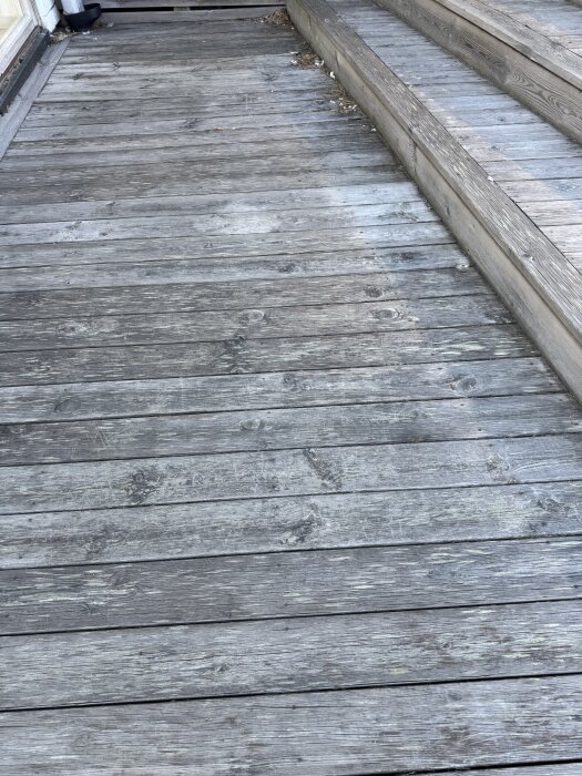 Altan med gamla, gråbruna trallbrädor, delvis rengjord med Kärcher PCL 6, visar skillnad mellan rengjord och icke rengjord yta.