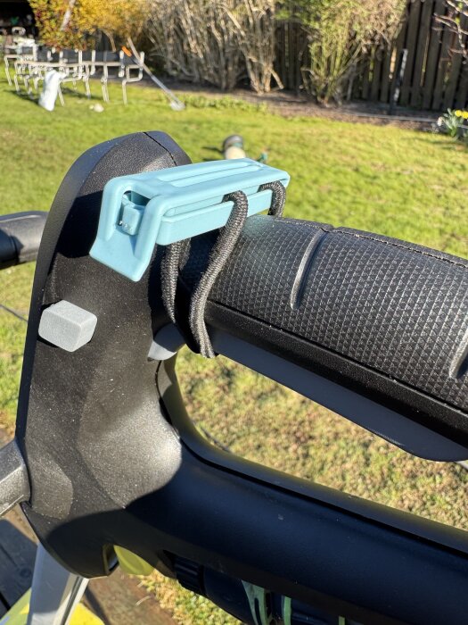 Kärcher PCL 6-handtag med blå klämma och snodd i trädgårdsmiljö.