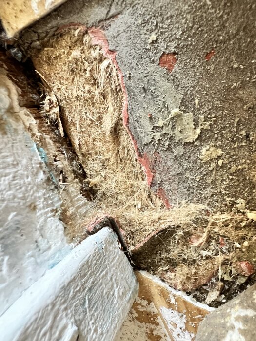 Gammal plastmatta med synliga fiber och slitage på golvet i ett hus från 1973. Frågetecken om risk för asbest eller om det är juteväv.