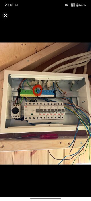 Elcentral med synliga kablar och en bygel markerad med en röd cirkel för borttagning.